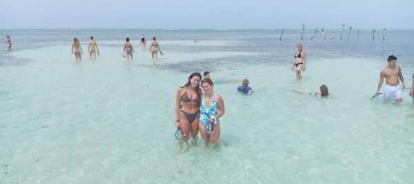 Turistas disfrutando de la arena blanca y aguas cristalinas en Isla Pelícano, Guna Yala.